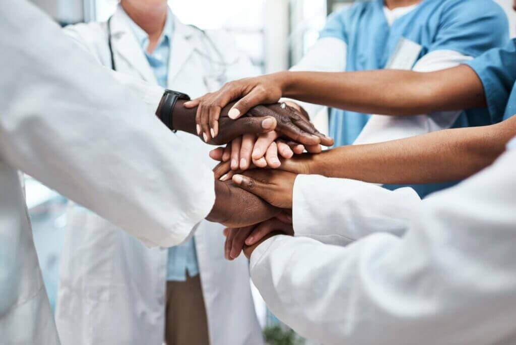 Medical team stacking hands together, close crop